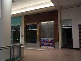 The closed Spencers in the Crossroads Mall. The door of the store is down, with Spencer's graffiti outline logo at the bottom.
