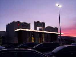The north center entrance of the Empire Mall, backlit by a blue and orange evening sky.